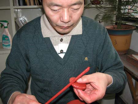 54、取下切割出來的“圈足底片”，用沾好稀泥的稀泥棒，沾黏稀泥平均的塗佈在“圈足底片”的上邊，如圖。