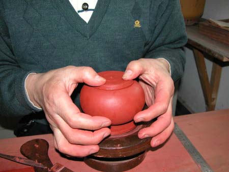 60、將塗好稀泥的“壺頸圈片子”壓貼上壺口上方的正中央。