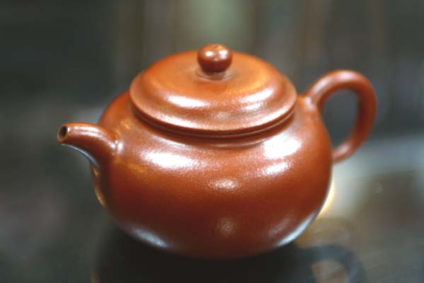 這把壺就是83茶癡的三代名劍~“三代嫣紅老朱泥”，與當日頭獎“牙山礫金朱砂”爭奪激烈，經二次重選才因“眉角處”有些茶垢而被遺憾地刷下成二獎；不過老朽卻對其晶瑩剔透度情有獨鍾，故破例“忍痛”捐出一件化骨綿掌~赤鱔茶海為二獎獎勵品。