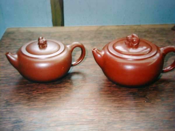 众所皆知，朱泥系的高收缩比，是制作成型之最高挑战。  本图中之右方壶是生胚(即未烧之前)，左方壶乃烧成后；两者之大小立即可辨，为朱泥系(图样是蜜瑰红，收缩达35%左右)的最明显特徵。(图样为高级工艺美术师韩洪波先生手制“聚珍壶”) 绝非一般红泥加铁红粉之品，仍维持红泥11%~12%之收缩比而已。