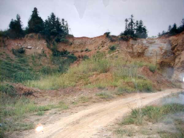 此照片为多年前古陶研究所余朽所摄；由宋迄今本尚存如图之一小片裸露的山坡(前方已被古人刨空成小水塘)，图中可见灰白色之甲泥矿夹带于土壤中；惟，不幸地，现今已夷为平地建铁路；朱泥的故乡~爱壶人的圣地~~赵庄山，已成历史名词矣...此照亦成历史资料矣！注：前方之小路是拖拉机(运矿车)碾跑出，通往赵庄山的路。